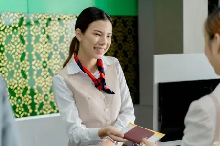 Uśmiechnięta kobieta trzyma w ręce paszport.